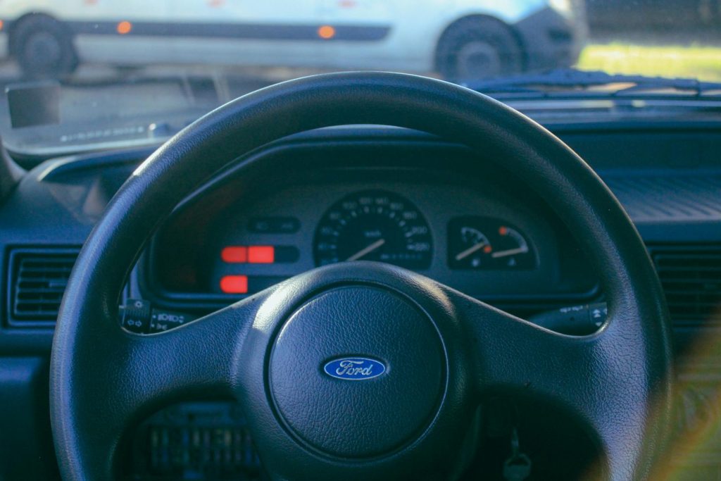 Close-up view of a classic Ford steering wheel, showcasing interior details.