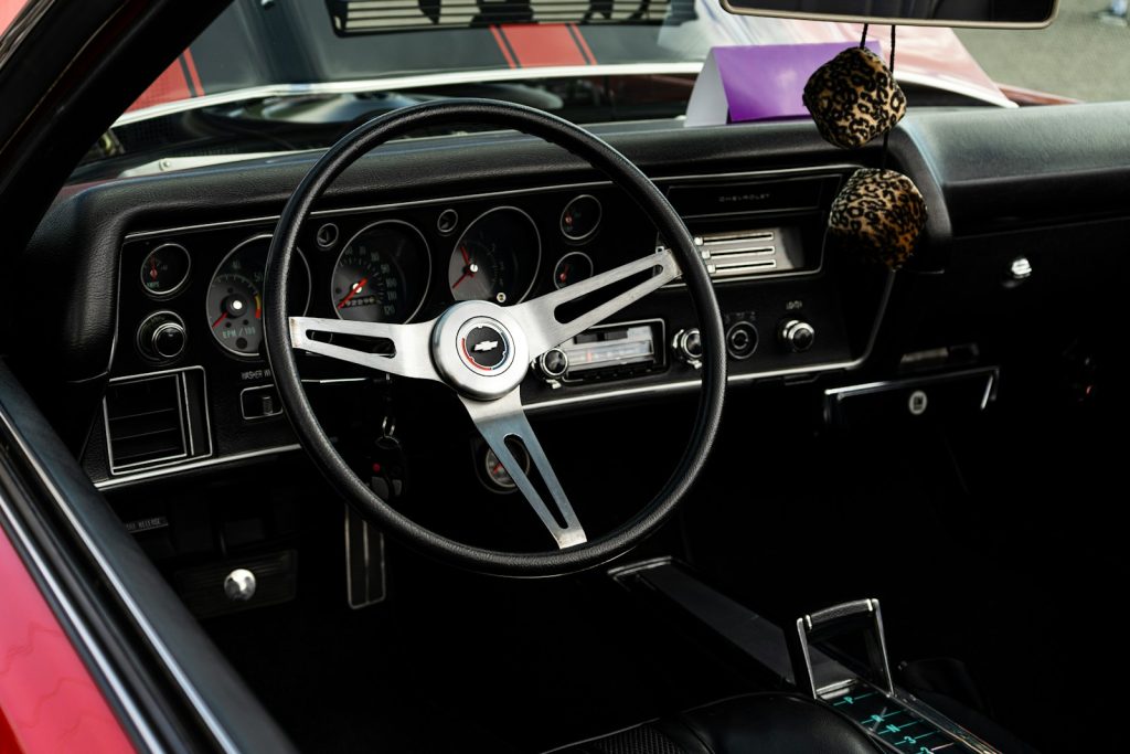 Interior view of a vintage car dashboard and steering wheel.