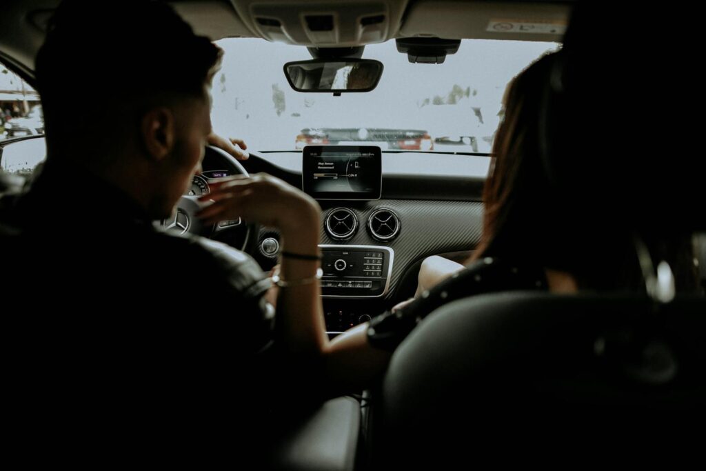 A couple enjoying a drive in a sleek modern car, showcasing the luxury interior.