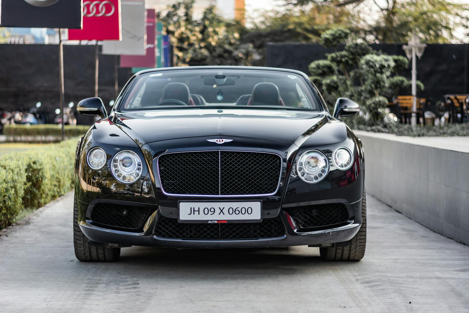 Front view of a sleek black Bentley Continental GT parked outdoors.