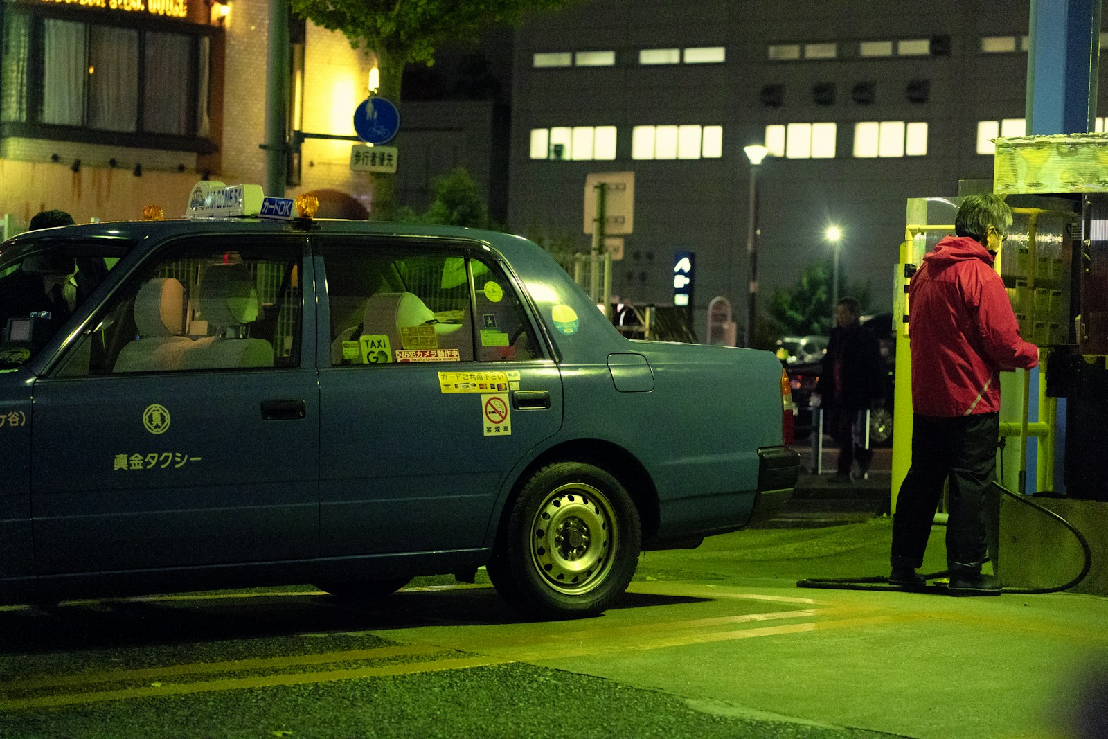 a blue taxi cab parked on the side of a road
