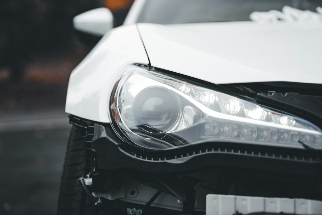 Close-up of a white sports car's headlight.