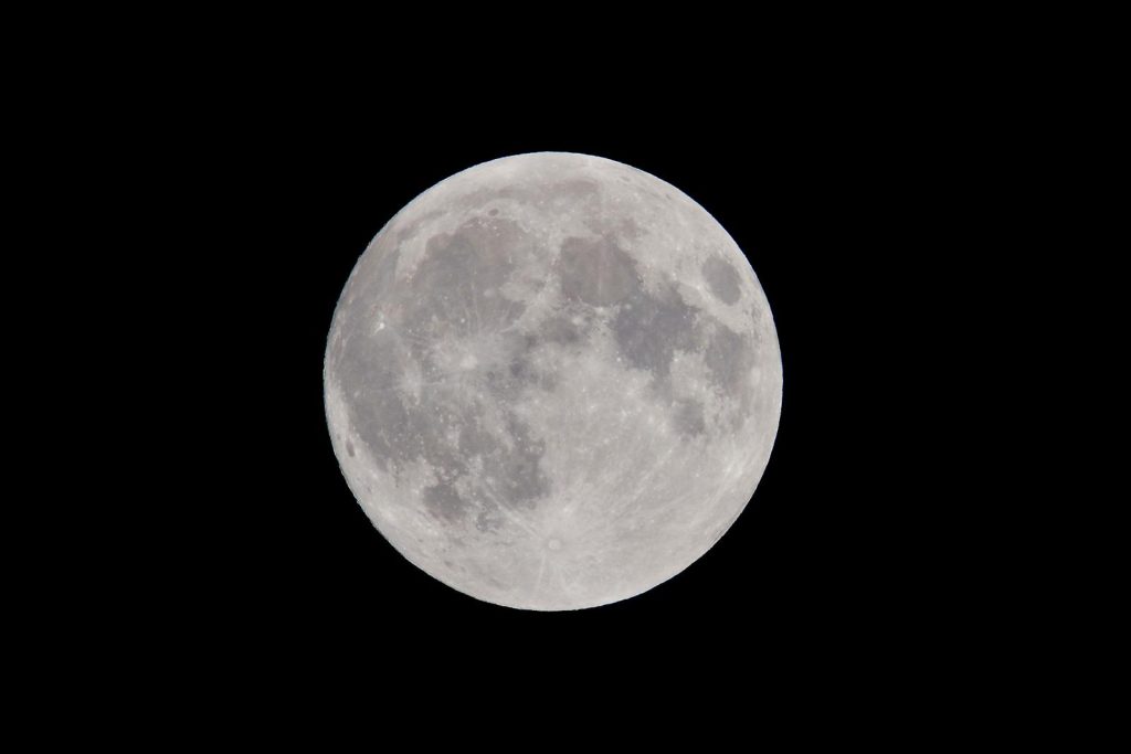 Stunning full moon against a dark night sky, showcasing captivating lunar details.
