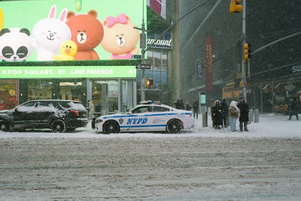 Nypd car on a snowy city street with billboards