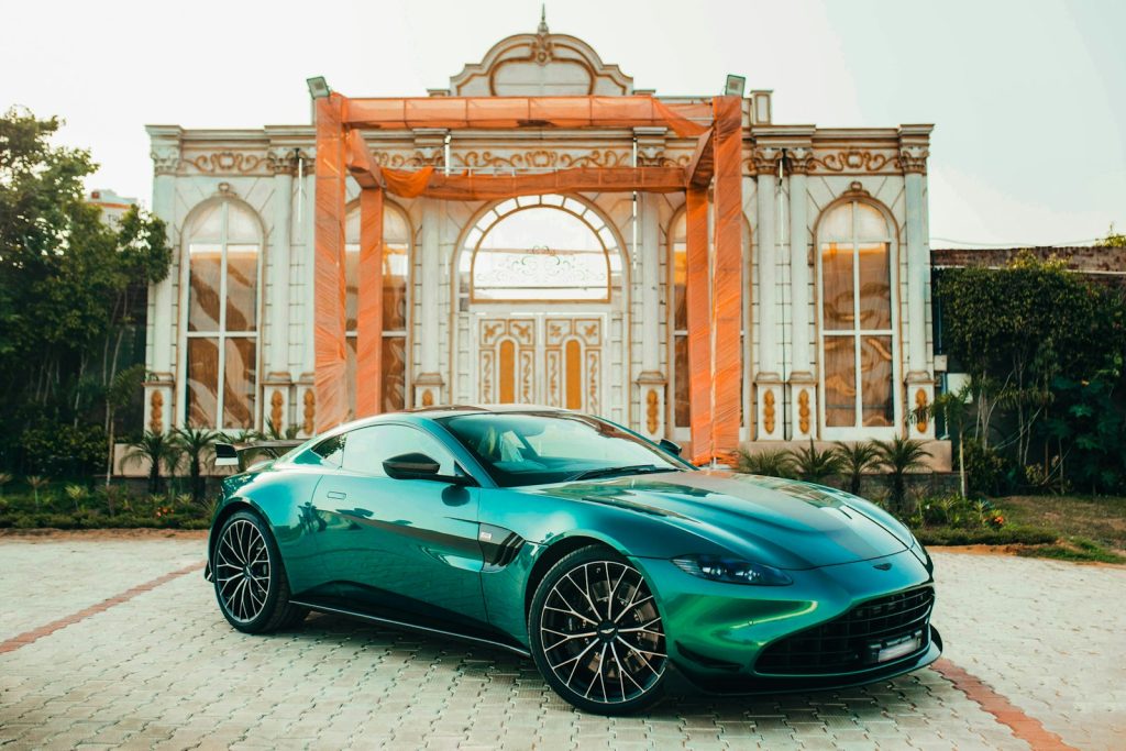 A green sports car parked in front of a building