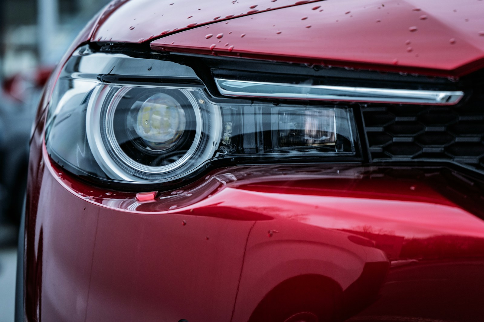 Close up of a red car headlight with water droplets.