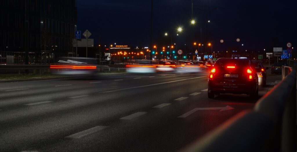 a car driving down a street at night