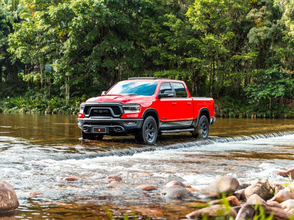 A red truck wades through the water.