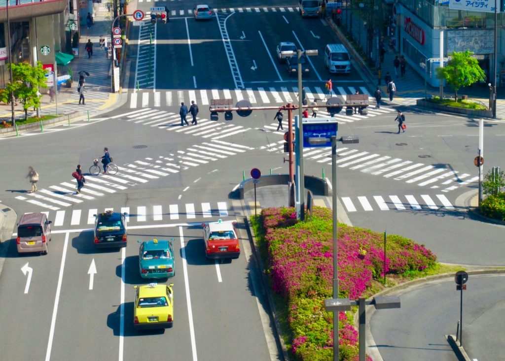a busy city intersection with cars and pedestrians