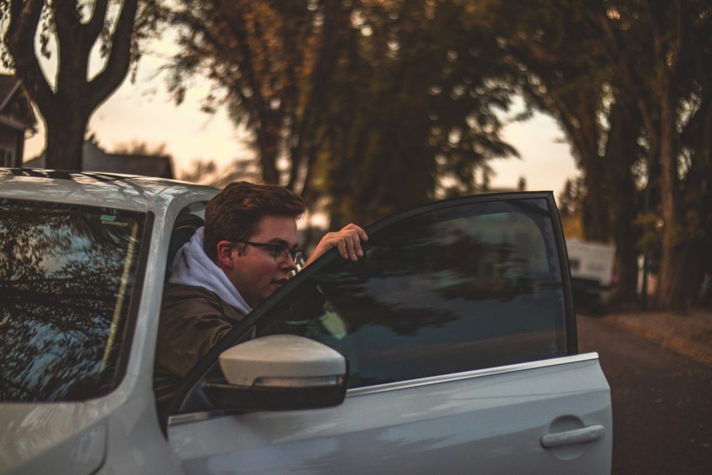 a man sitting in the drivers seat of a car