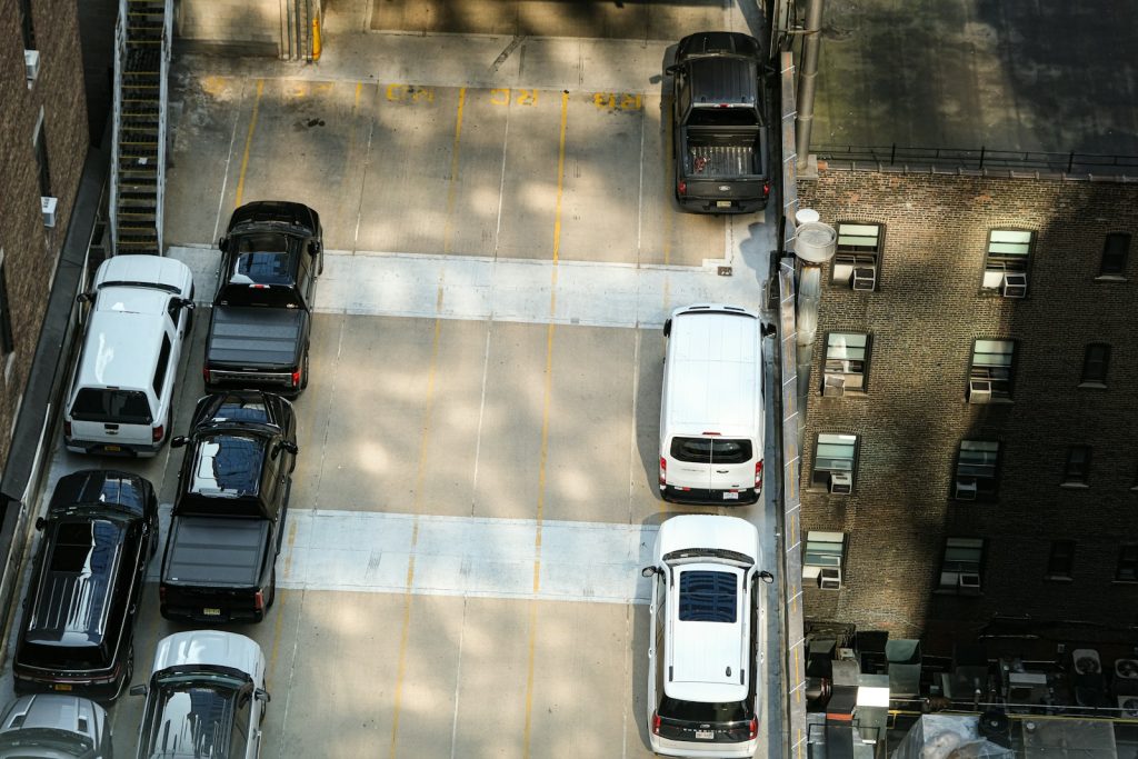 Cars parked in an outdoor lot with shadows.