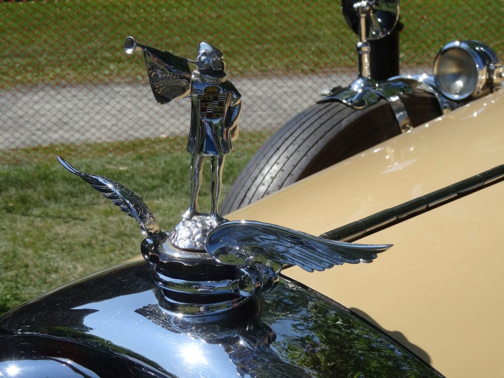 Chrome hood ornament with eagle and figure.