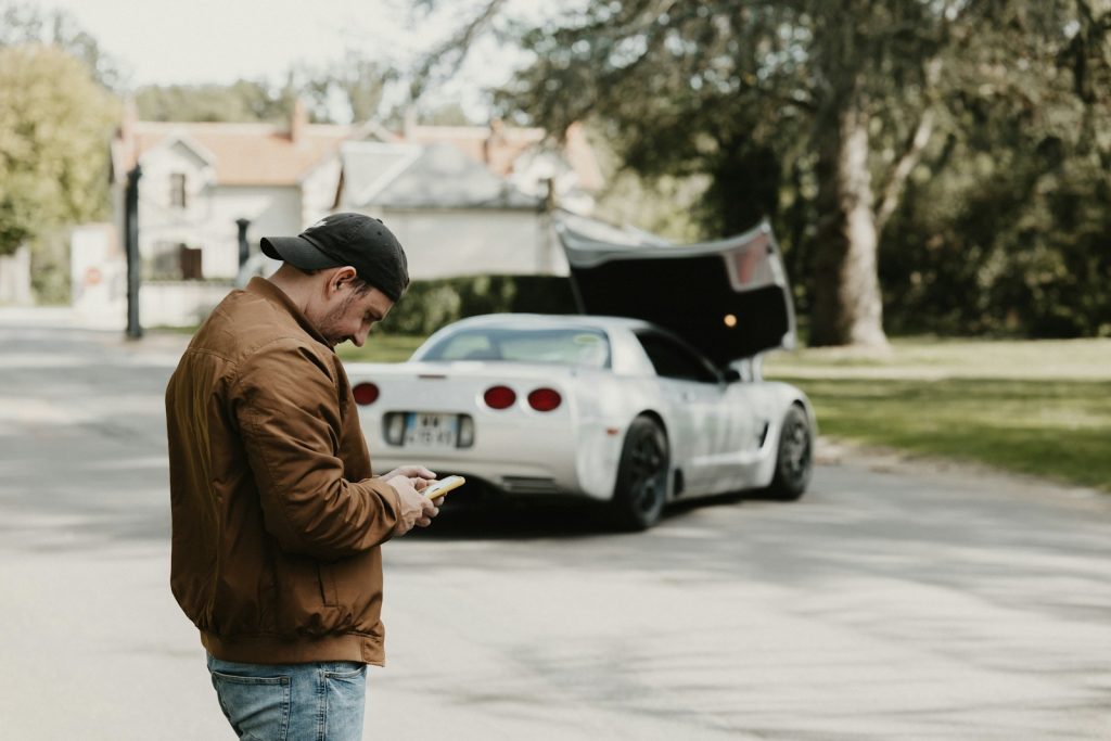a man standing in the street looking at his cell phone