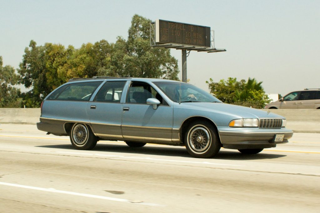 Light blue station wagon driving on highway