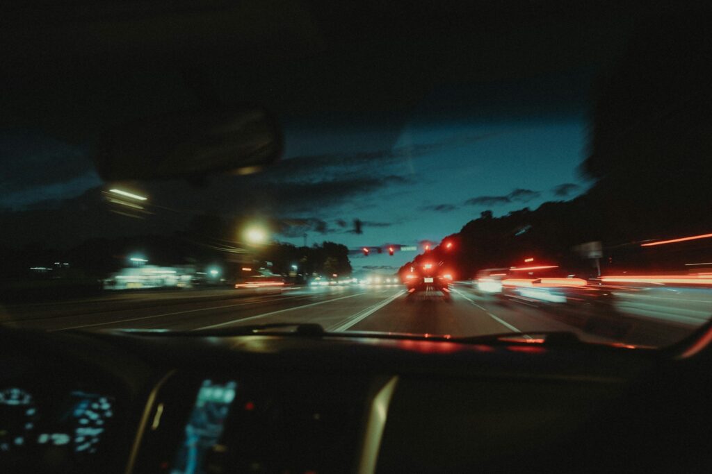 a car driving down a street at night