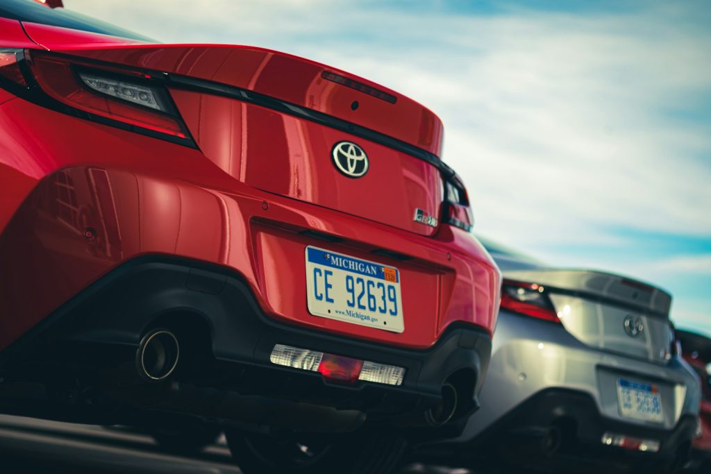 a red car with a black car behind it