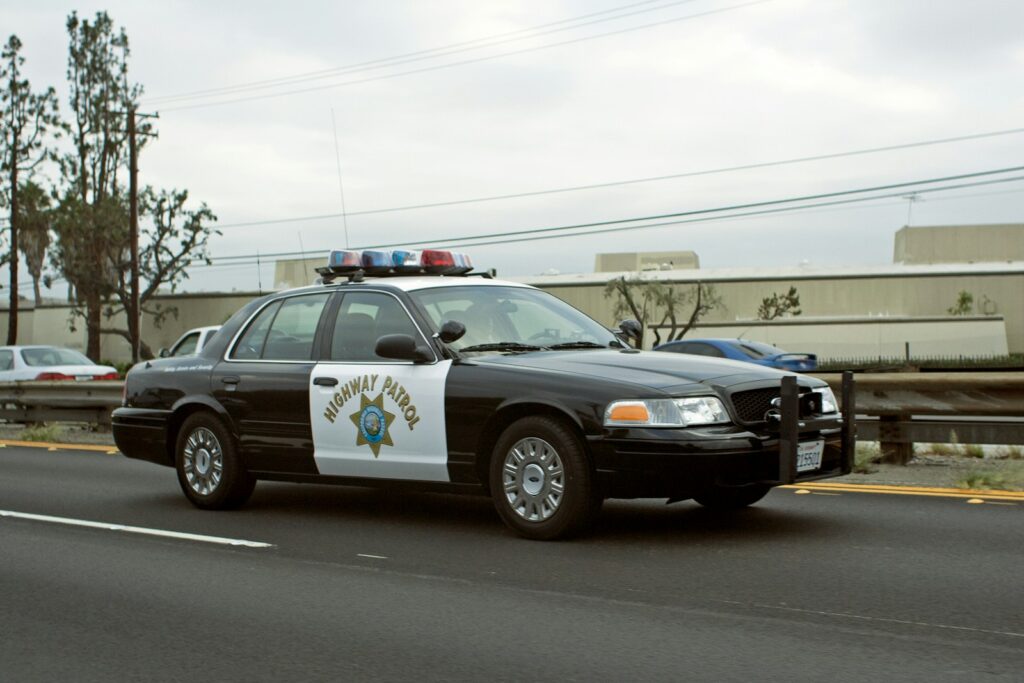 A california highway patrol car drives down the road.