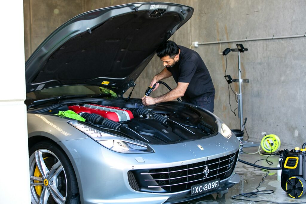 A mechanic is working on a ferrari car.
