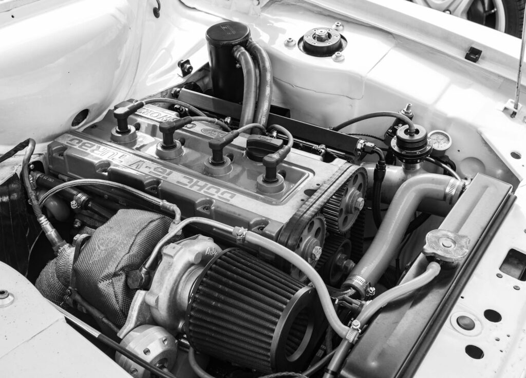 Close-up view of a high-performance car engine in black and white showcasing intricate details.