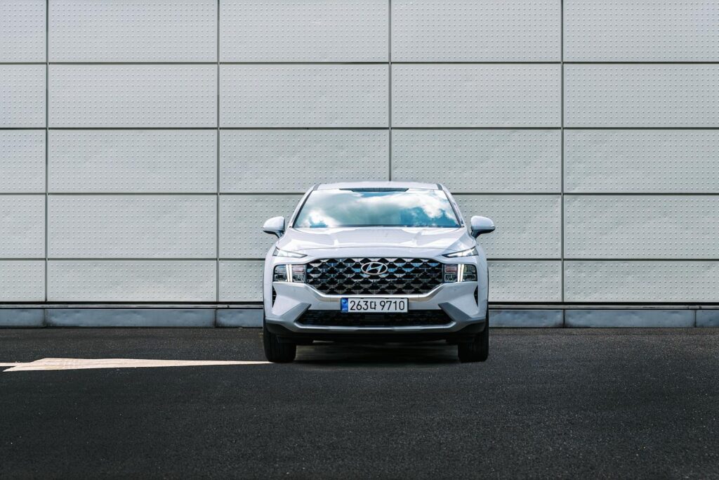 Front view of a Hyundai Santa Fe parked against a geometric urban wall design, showcasing its exterior.