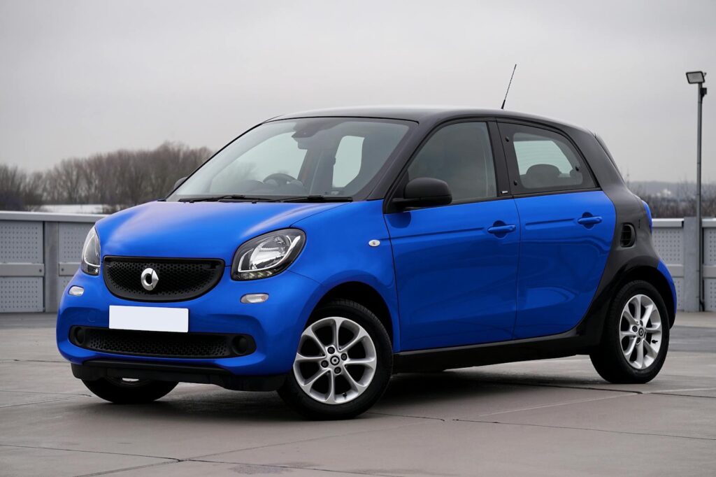 A sleek blue Smart Forfour car parked outdoors in an urban setting.