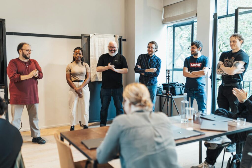 A diverse group of adults engaging in a casual team meeting indoors.