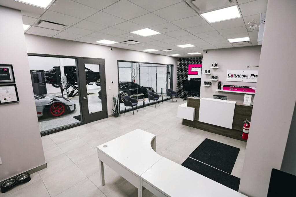 Spacious and modern car salon with luxury cars in a pristine interior setting.