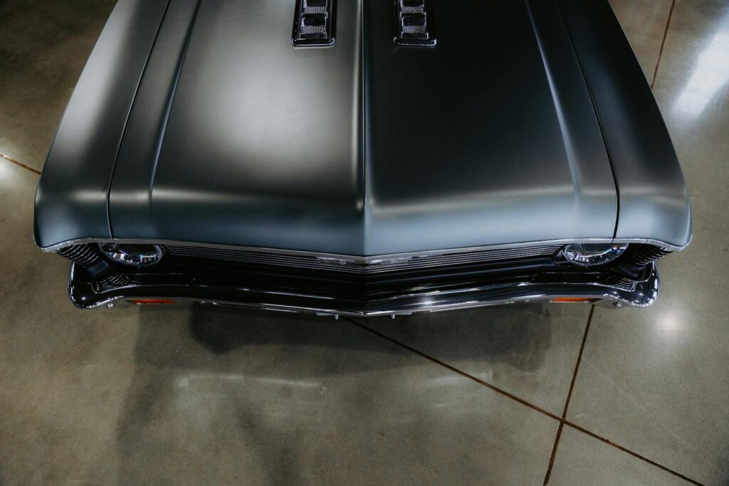 Top view of a classic muscle car with sleek design in a garage setting.