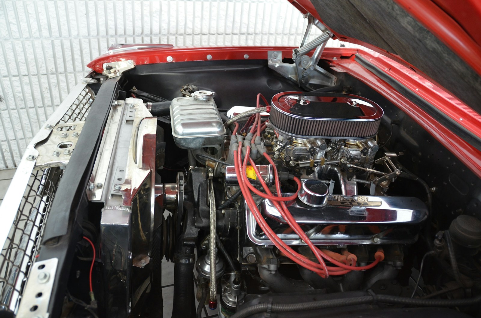 the engine compartment of a red car with its hood open