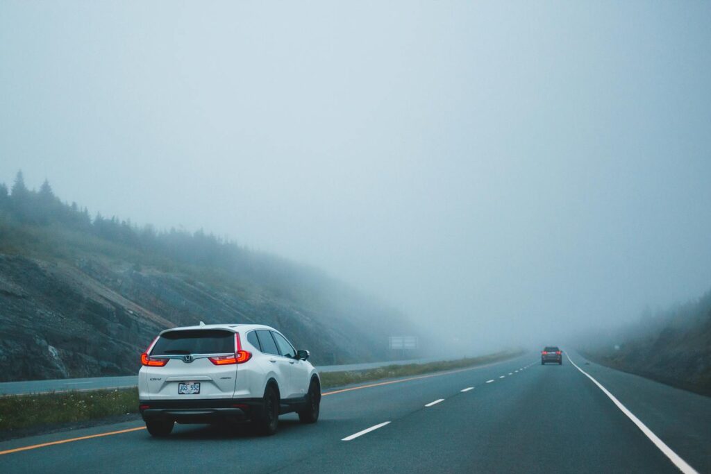 Cars driving on a foggy highway, creating a mysterious and serene atmosphere.