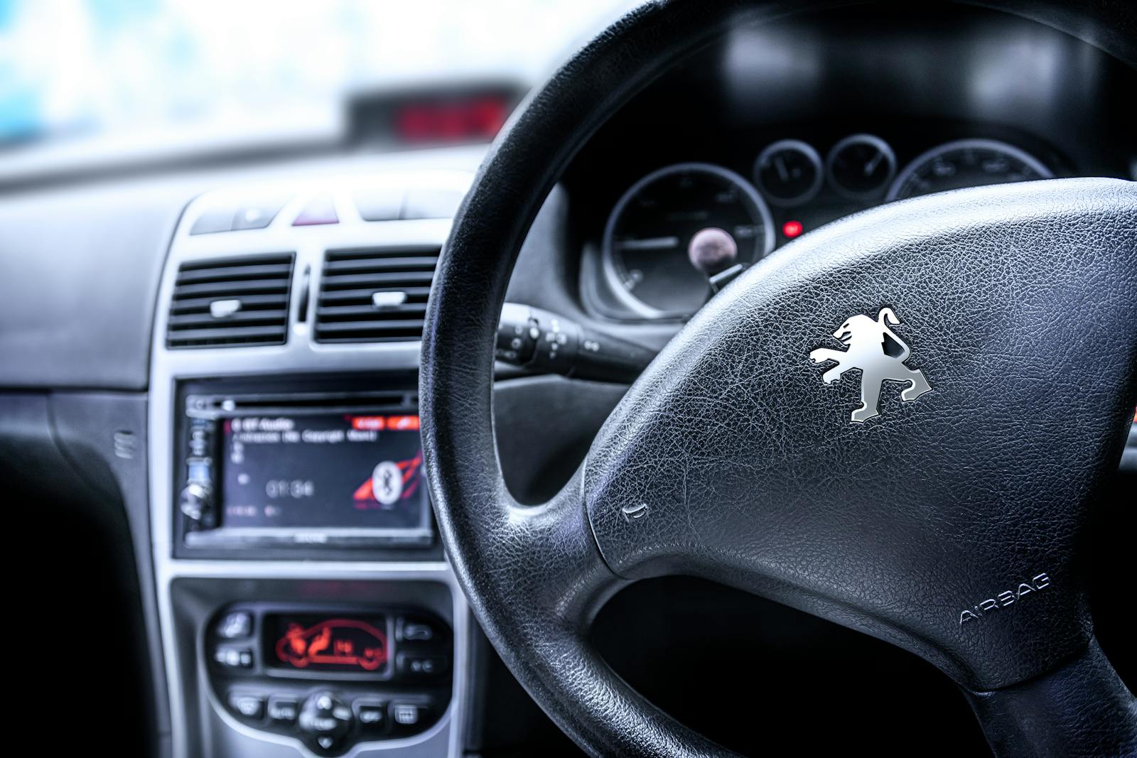 Detailed view of a car steering wheel featuring a prominent emblem, highlighting automotive design.