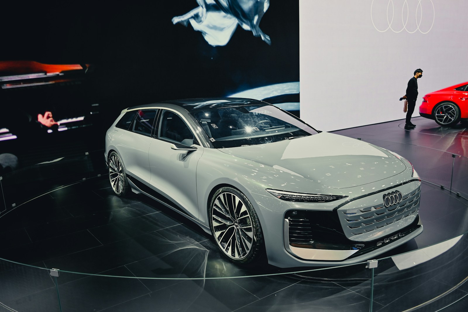 a man standing next to a car on display