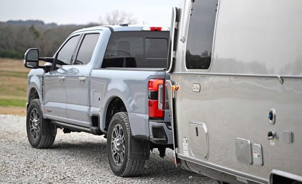 A silver truck parked on a gravel road