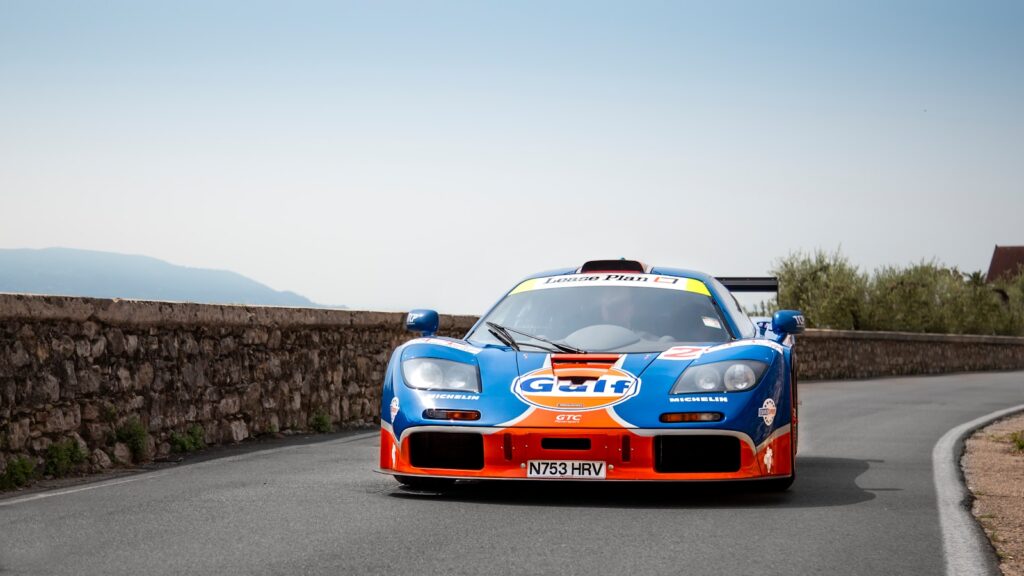 A blue and orange race car driving down a road