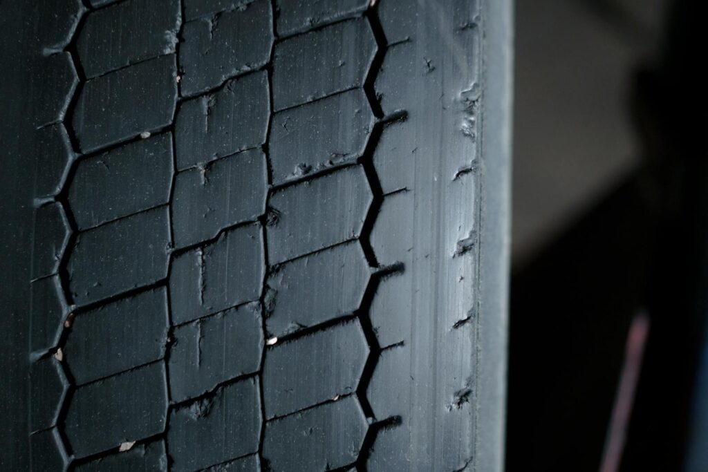 Detailed close-up of a worn tire tread showcasing grooves and patterns.