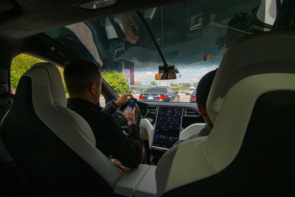 Inside a Tesla vehicle in city traffic, showcasing modern technology and urban driving.