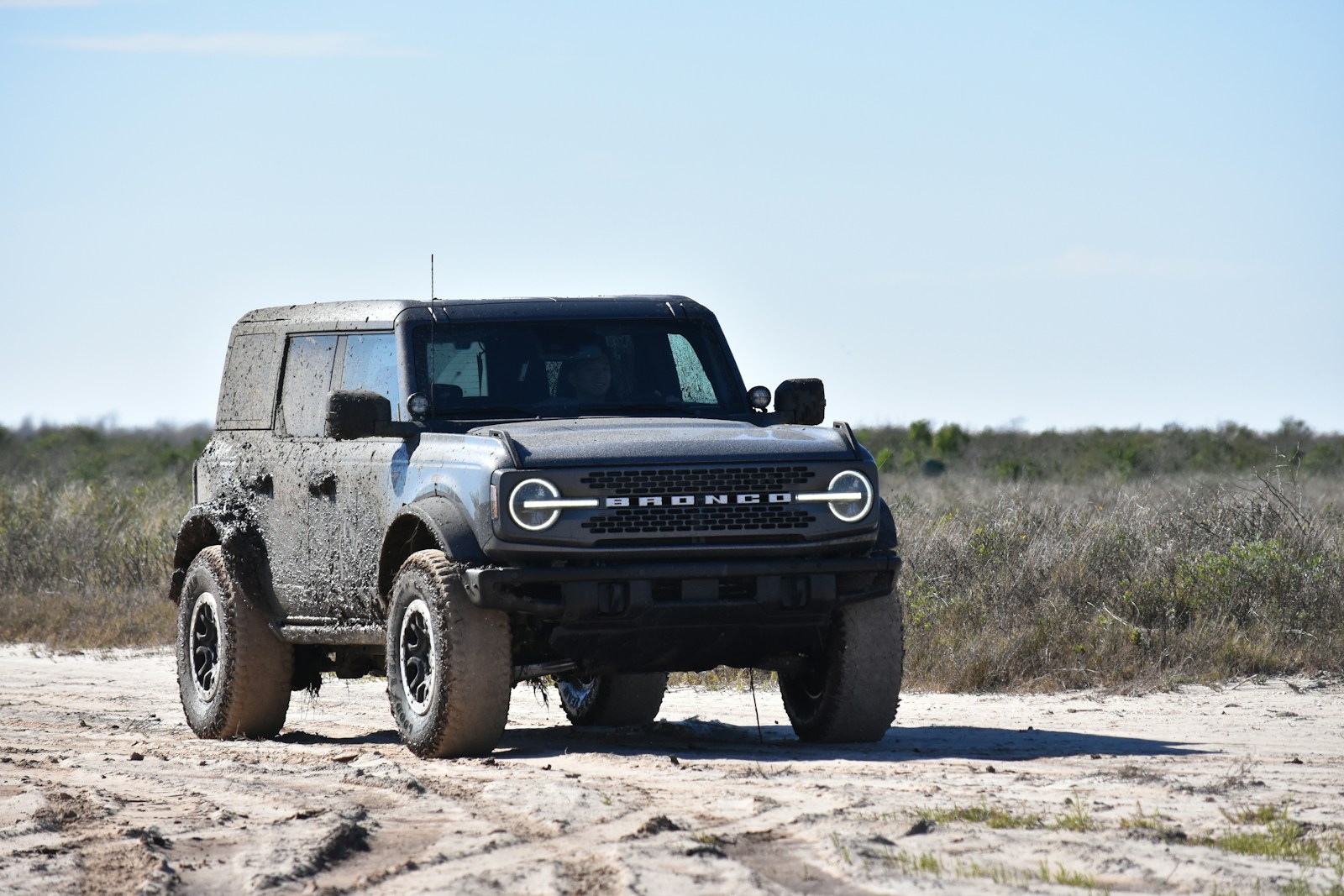 a black truck parked on a dirt road