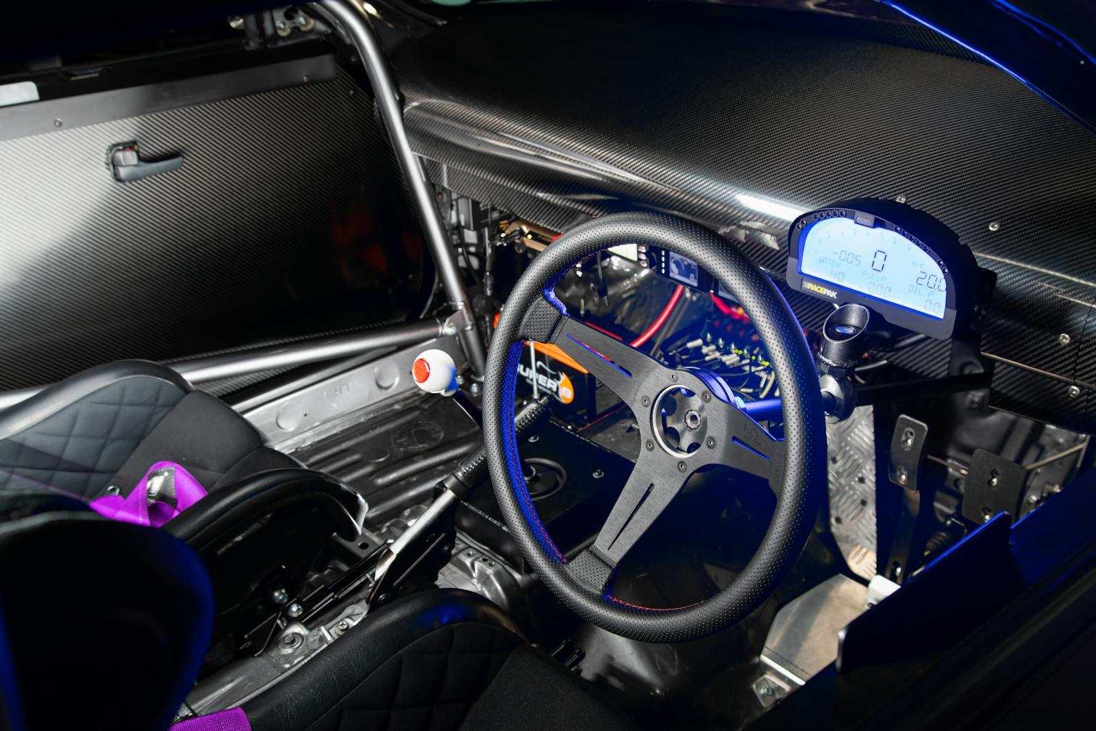Interior of a high-performance racing car showing steering wheel and digital dashboard.