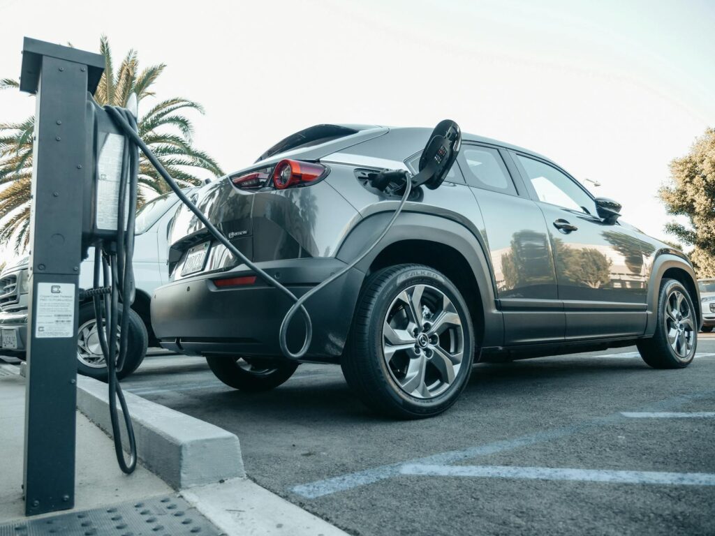 Modern electric vehicle charging at an outdoor station in daylight.