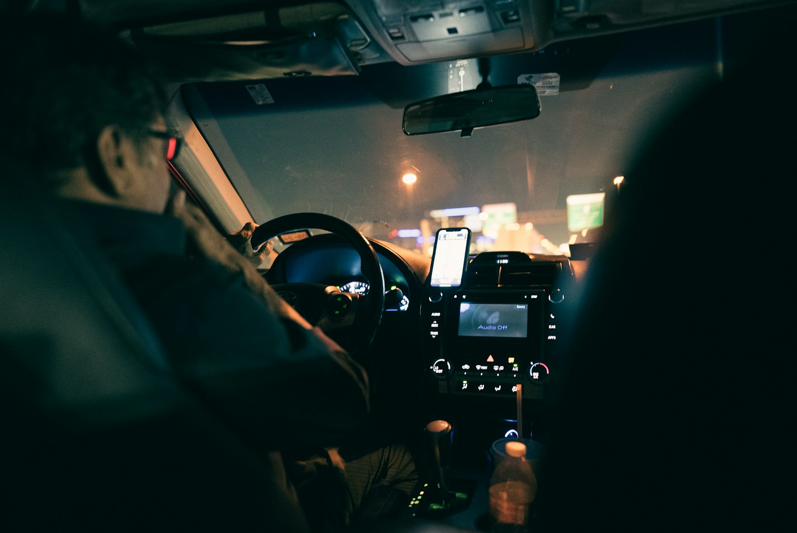 a man driving a car at night in the dark