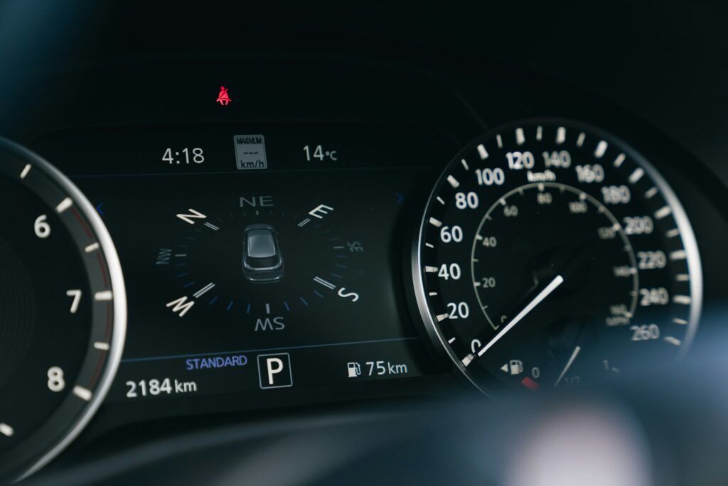 Car dashboard with speedometer and digital display.