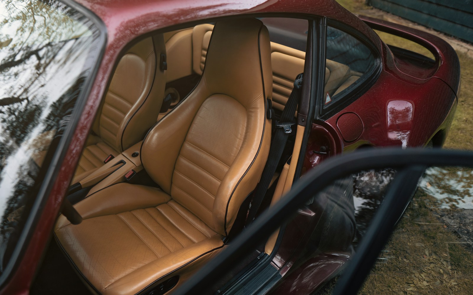 The interior of a red car is covered in snow