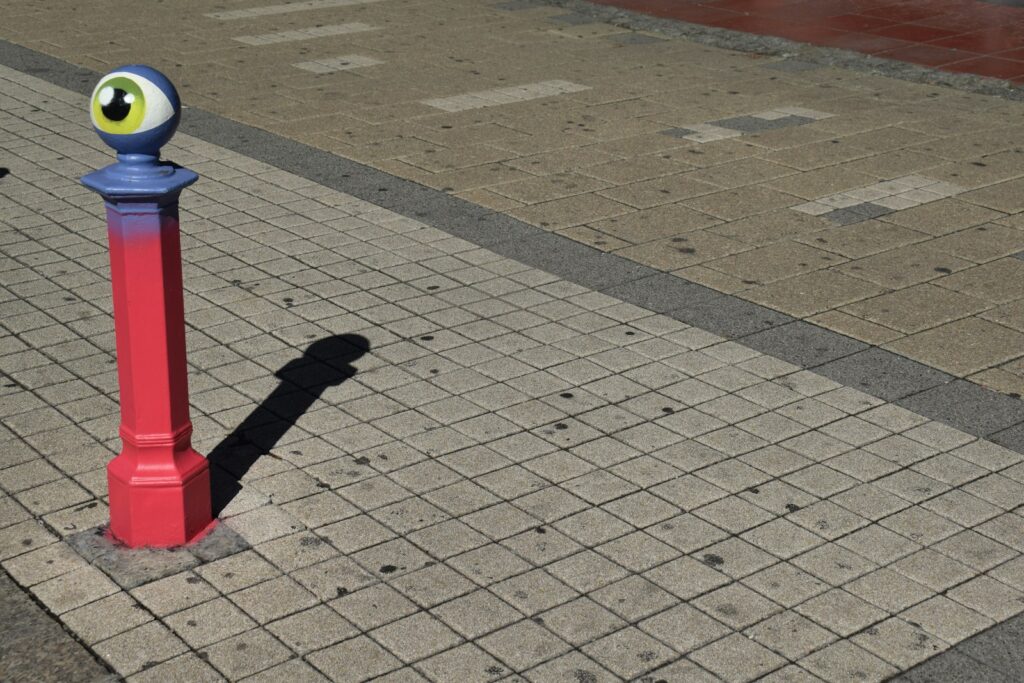 A blue and red pole with a fake eye on it