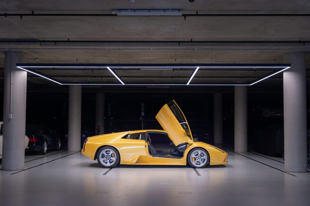 Yellow sports car with doors open in garage