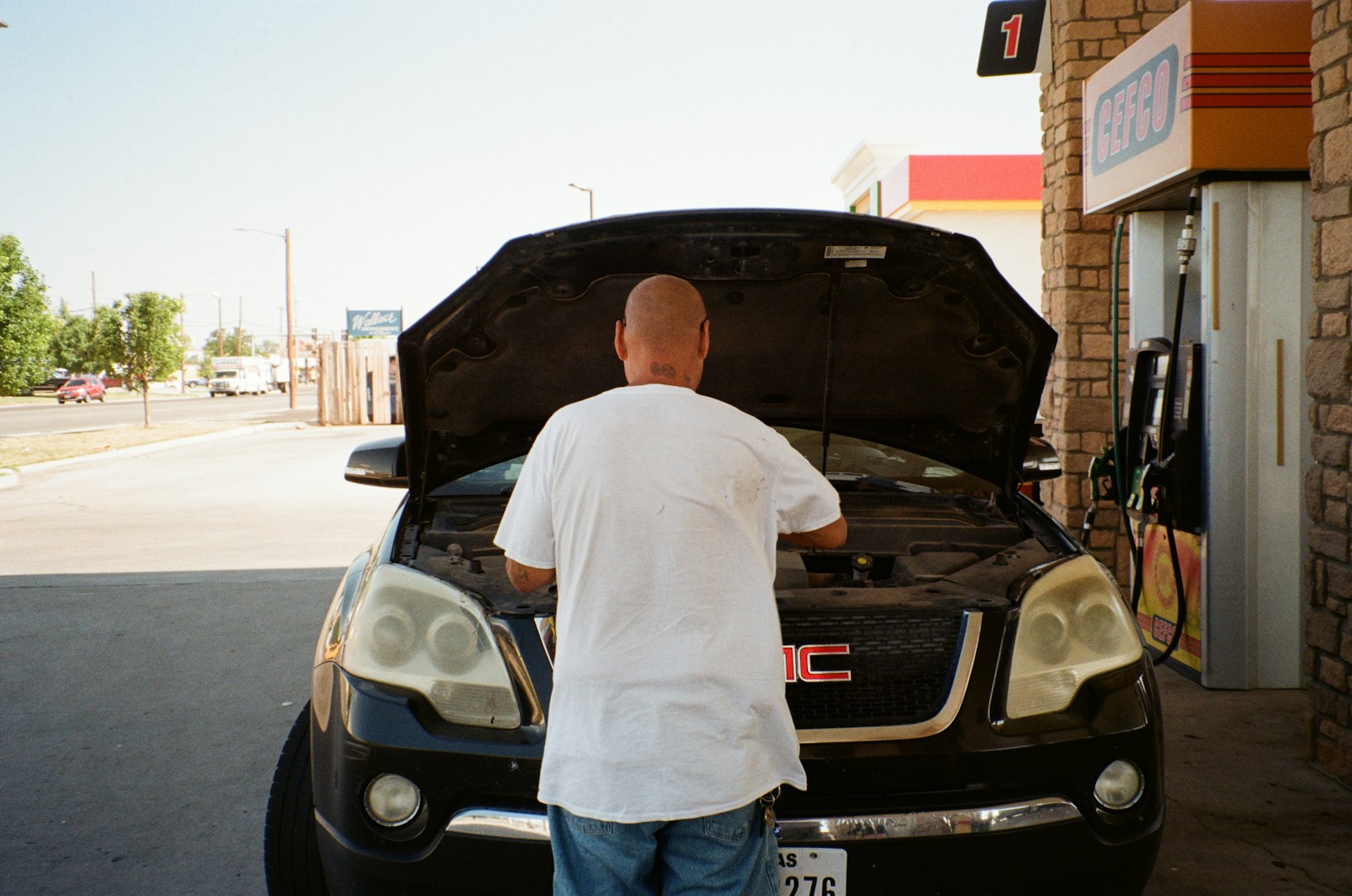 A man standing next to a car with its hood open