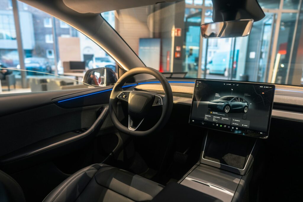The interior of a car with a laptop on the dashboard