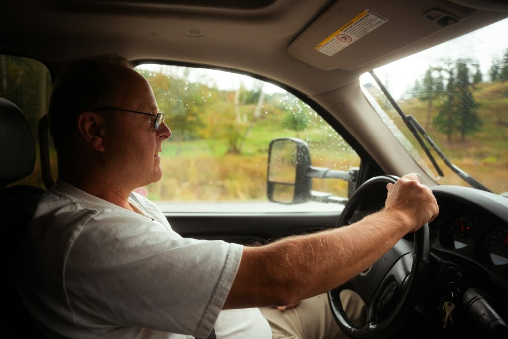 A man driving a car on a rural road