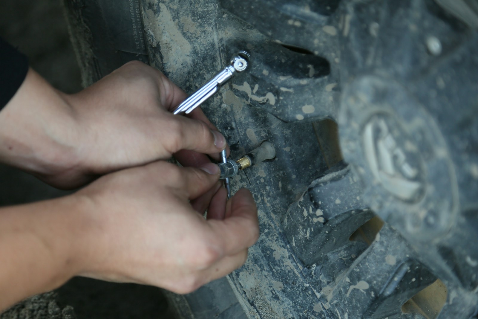 person putting on a pin on vehicle tire