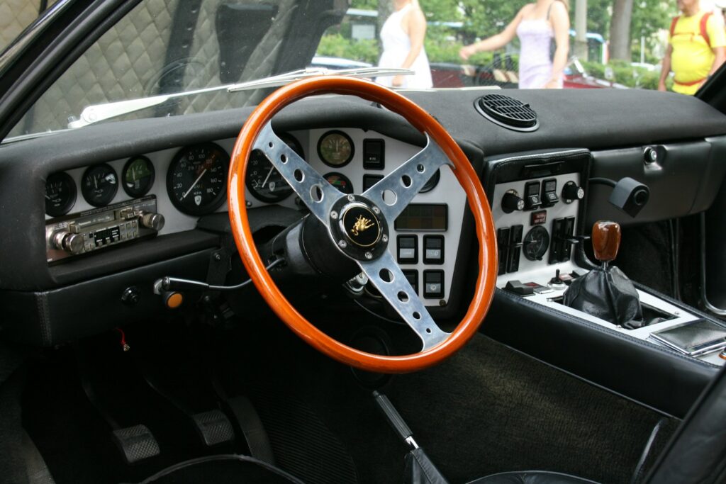 The interior of a car with a steering wheel and dashboard