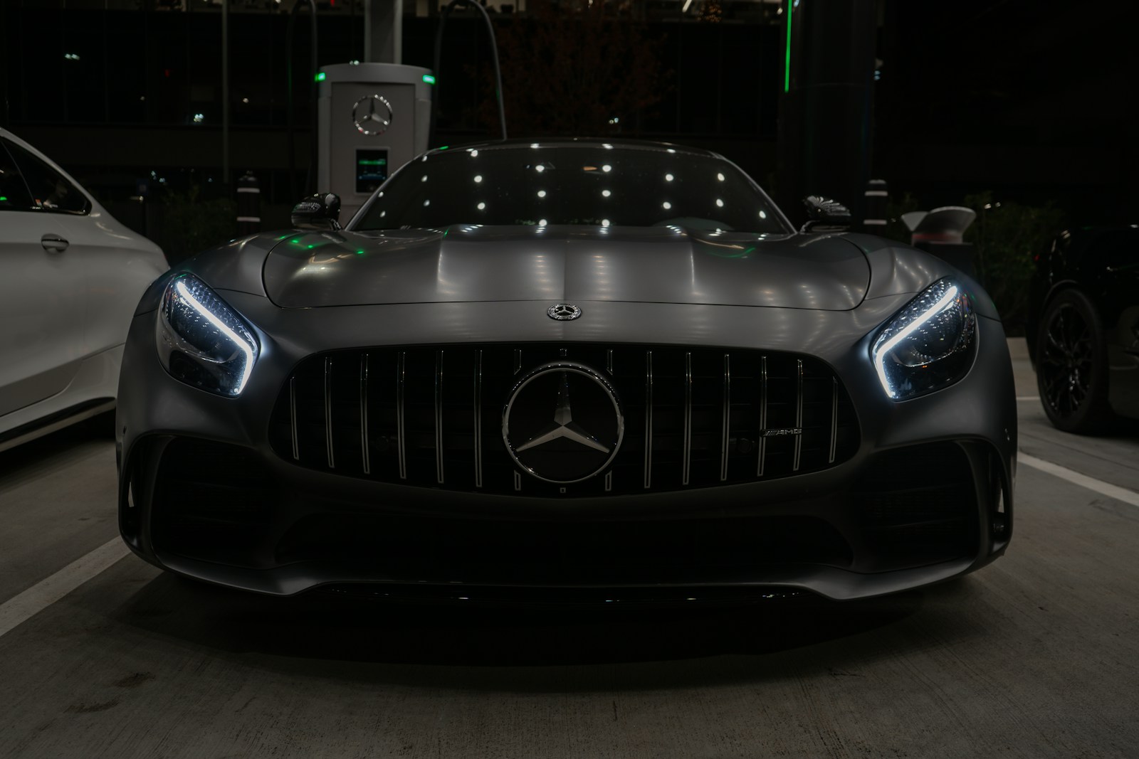 A black car driving down a street next to a white car